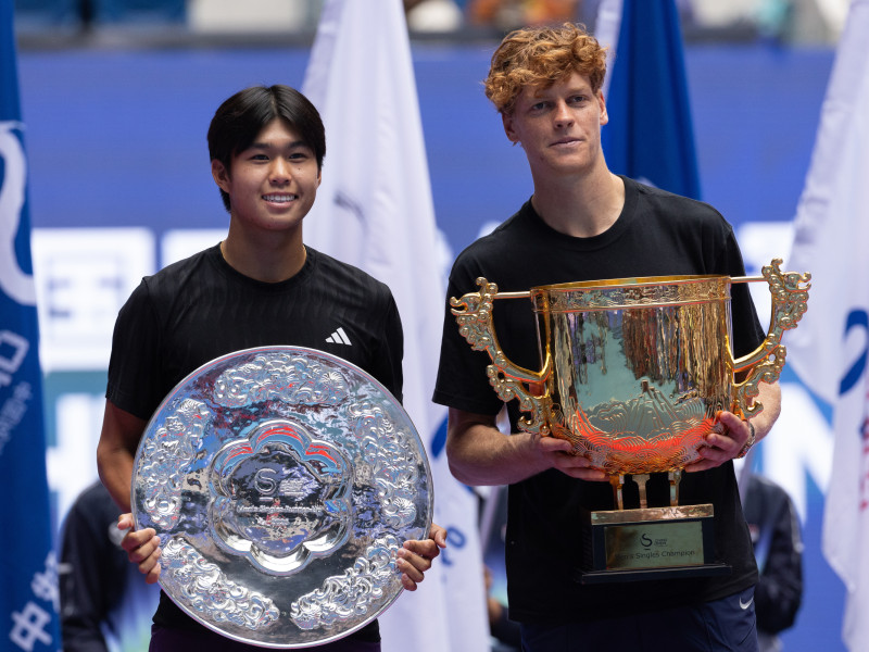 Learner Tien y Jannik Sinner posan con los trofeos de subcampeón y campeón del torneo de Pekín.