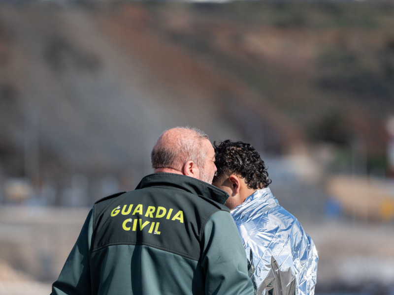 Agentes de la Guardia Civil española detienen a un joven marroquí que intentaba cruzar a nado la frontera de El Tarajal en Ceuta