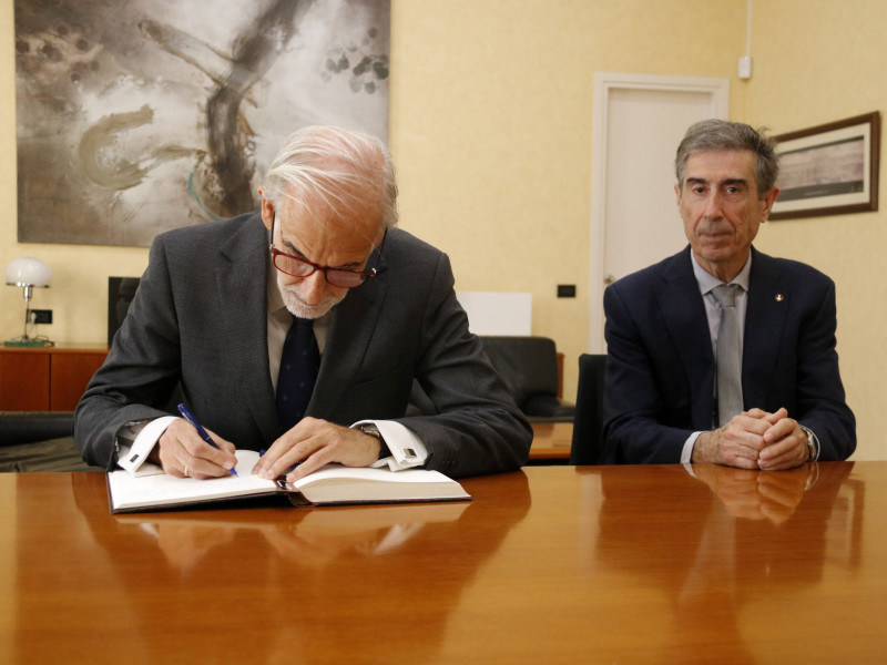 El catedràtic i exprofessor de la UdL, Juan M. Pemán, signa el llibre d'honor de la UdL al costat del rector del centre, Jaume Puy