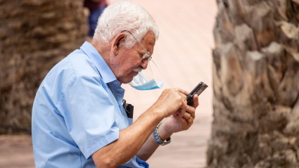 Un jubilado mira su teléfono móvil en Las Palmas