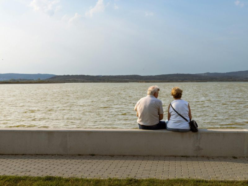 Pareja de ancianos sentados frente al mar
