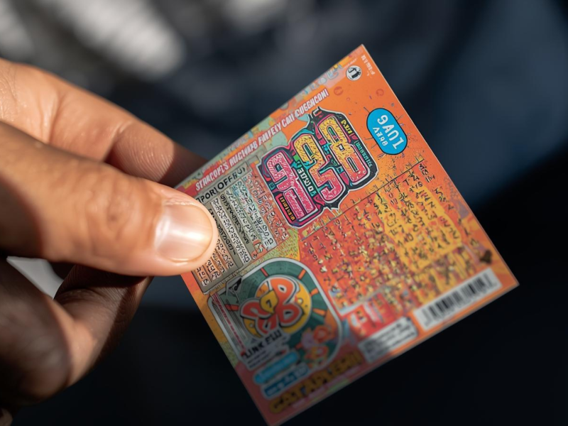 Una persona tiene un boleto de rasca y gana en la mano