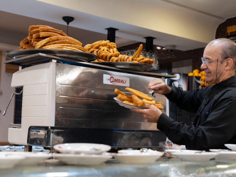 Un camarero sirve churros y porras tradicionales en Madrid