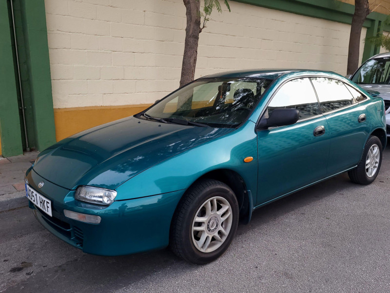 Mazda 323F estacionado en la calle