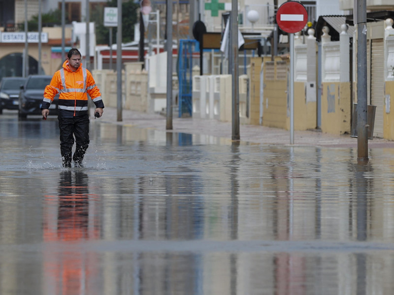 Un miembro de protección civil recorre una calle anegada en Xeraco