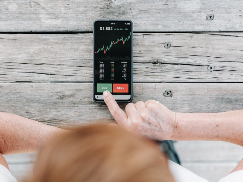 Mujer inversionista que utiliza una aplicación de inversión en su teléfono móvil para comprar criptomonedas