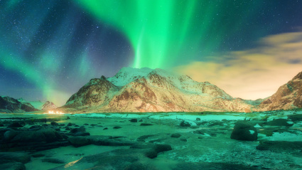 PF8X7X Aurora over snowy mountains. Northern lights in Lofoten islands, Norway. Starry sky with polar lights. Night winter landscape with green aurora boreal
