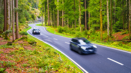 Dos coches circulan por una carretera secundaria
