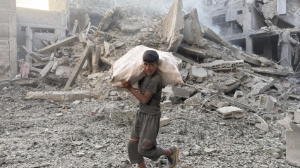 Una persona camina por los escombros tras uno de los ataques lanzados este domingo por Israel en Gaza