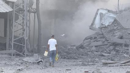Un hombre camina por los escombros tras uno de los ataques lanzados este domingo por Israel en Gaza