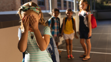 Imagen de recurso de un grupo de niños haciendo bullying a una niña