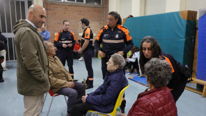 Miembros de Protección Civil de Gijón, con los afectados por el incendio del Monte Areo