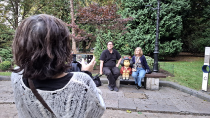 Un turista se saca una foto con la escultura de Mafalda en Oviedo