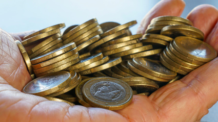 Manos sosteniendo una pila de monedas de euro