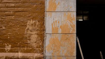 En una pared se ven siluetas de manos hechas con barro. en Catarroja