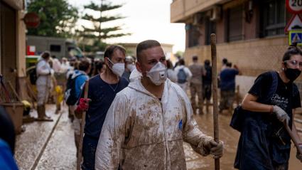 Voluntarios caminando por las calles llenas de barro en Catarroja