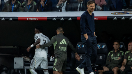 Un trabajador del Real Madrid sujeta a Vinicius Jr. (7) detrás de Xabi Alonso, entrenador del Real Madrid, durante el partido de La Liga 2025-2026 de EA SPORTS entre el Real Madrid y el FC Barcelona, disputado en el estadio Santiago Bernabéu.