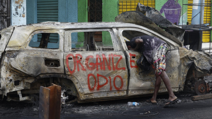 Fotografía de dos vehículos incinerados en una calle en Río de Janeiro