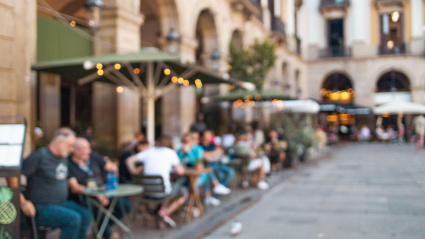 Personas toman café en la terraza de un restaurante en Valencia