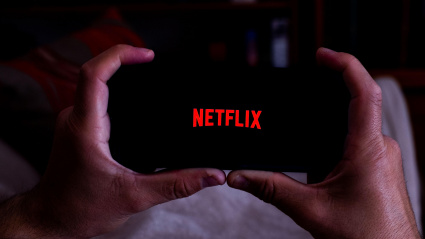 Imagen de recurso de un hombre viendo una serie de Netflix en el móvil