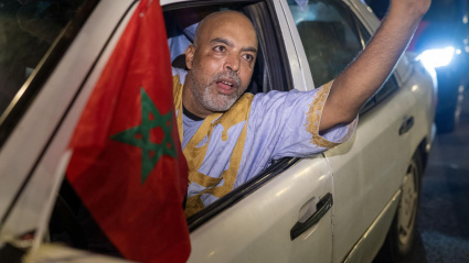 La gente ondea banderas y celebra en una calle de Rabat.