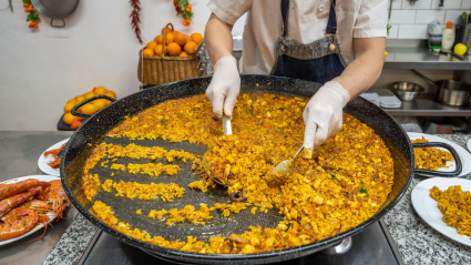 Cocine sirviendo una paella de marisco, Valencia