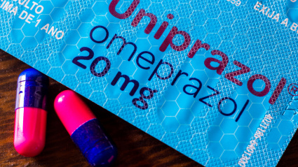 En esta ilustración fotográfica se muestra un paquete de Omeprazol con algunas pastillas.