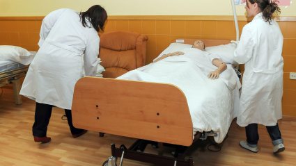 Estudiantes de enfermería cuidan a un maniquí que yace en una cama de hospital en Zamora