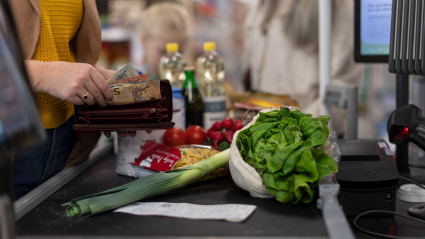 Una mujer compra con dinero en efectivo en un supermercado