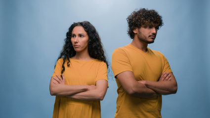 Angry mad Hispanic woman screaming scolds Indian man showing blah blah gesture multiracial couple quarrel argue angry conflict problem family trouble bad relationship offended blue studio background. High quality 4k footage