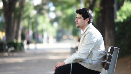 Una persona asseguda en un banc de la ciutat