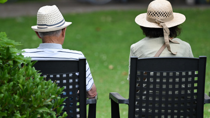 Dos jubilados de espaldas sentados en un banco