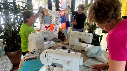 Voluntarias tejiendo la colcha del CRA "Los Llanos" con motivo del 25N