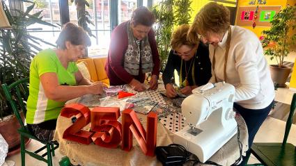 Voluntarias tejiendo la colcha del CRA "Los Llanos" con motivo del 25N