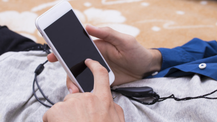 Un joven sostiene un móvil con batería baja