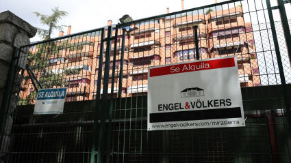 En la valla de una urbanización, se ven colgados dos carteles de 'Se alquila'.
