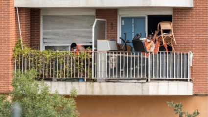 Trabajadores sacan al balcón de un domicilio las pertenencias de familias desalojadas. Imagen de archivo