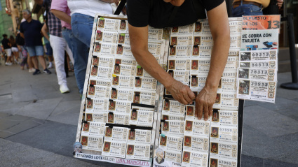 Una mujer vende décimos de lotería de Navidad en Madrid