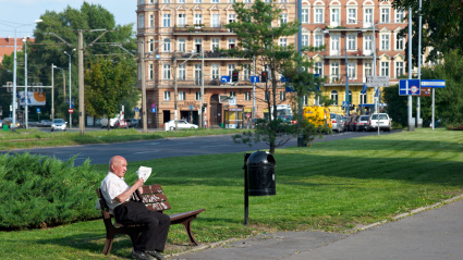 Hombre mayor sentado en un banco en un parque