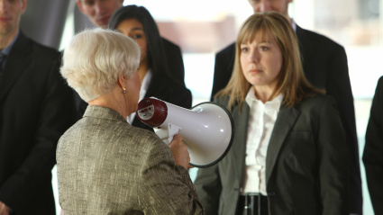 Una mujer habla con un altavoz a otra