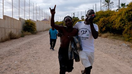 Varios migrantes se dirigen al Centro Temporal de Inmigrantes (CETI), mientras celebran el salto de la valla de Melilla, a 24 de junio de 2022, en Melilla