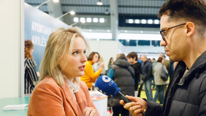 Marta Codrean, de Caja Rural de Asturias, atendiendo a COPE en el stand de la Caja Rural