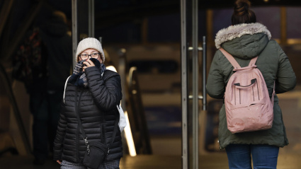 Una viandante se protege del frío en el centro de Madrid, este jueves. La llegada de aire de origen ártico por el norte de España trae este jueves ambiente muy frío, heladas generalizadas y copiosas nevadas en cotas muy bajas.