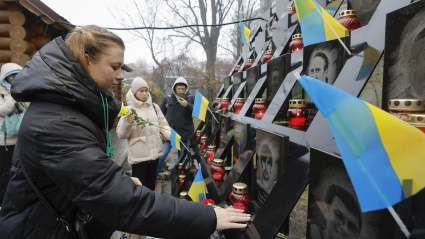 Ucranianos depositan flores y encienden velas en el monumento a los "Héroes de la Centena Celestial", en memoria de los activistas asesinados durante las protestas de Euromaidán en 2014, cerca de la Plaza de la Independencia en Kiev.