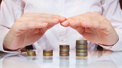 Un hombre hace varias montañas de monedas