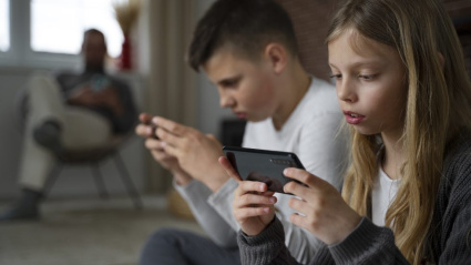 Niños usando el dispositivo móvil. Freepik