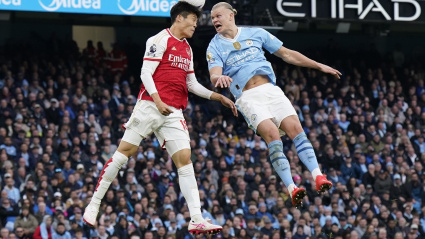 Takehiro Tomiyasu disputa un balón con Erling Haaland