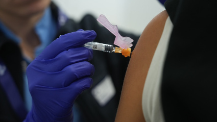 Una persona se vacuna, en un centro de refuerzo de vacunación frente a la gripe