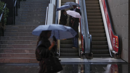 Personas con paraguas en las Cuatro Torres de Madrid