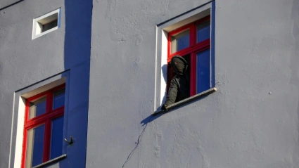 Un okupa enmascarado se asoma a la ventana de una viviendaUn okupa enmascarado se asoma a la ventana de una vivienda